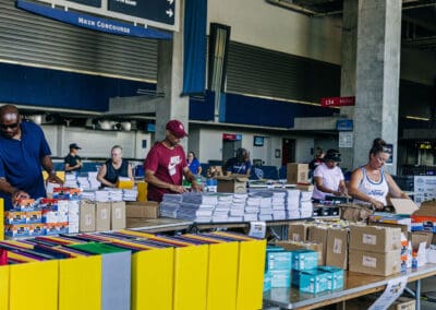 volunteers sorting school supplies at nissan stadium July 2024