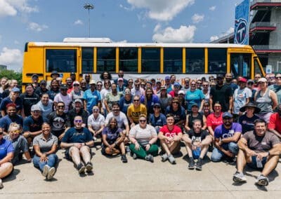 group photo of volunteers by school bus